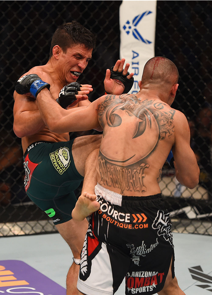 LAS VEGAS, NV - MAY 23: (L-R) Joseph Benavidez kicks John Moraga in their flyweight bout during the UFC 187 event at the MGM Grand Garden Arena on May 23, 2015 in Las Vegas, Nevada. (Photo by Josh Hedges/Zuffa LLC/Zuffa LLC via Getty Images)