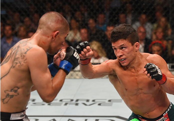 LAS VEGAS, NV - MAY 23:  (R-L) Joseph Benavidez punches John Moraga in their flyweight bout during the UFC 187 event at the MGM Grand Garden Arena on May 23, 2015 in Las Vegas, Nevada.  (Photo by Josh Hedges/Zuffa LLC/Zuffa LLC via Getty Images)