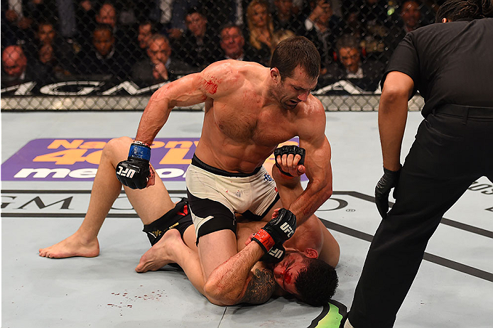 LAS VEGAS, NV - DECEMBER 12: Luke Rockhold (top) punches Chris Weidman in their UFC middleweight championship bout during the UFC 194 event inside MGM Grand Garden Arena on December 12, 2015 in Las Vegas, Nevada. (Photo by Josh Hedges/Zuffa LLC/Zuffa LL