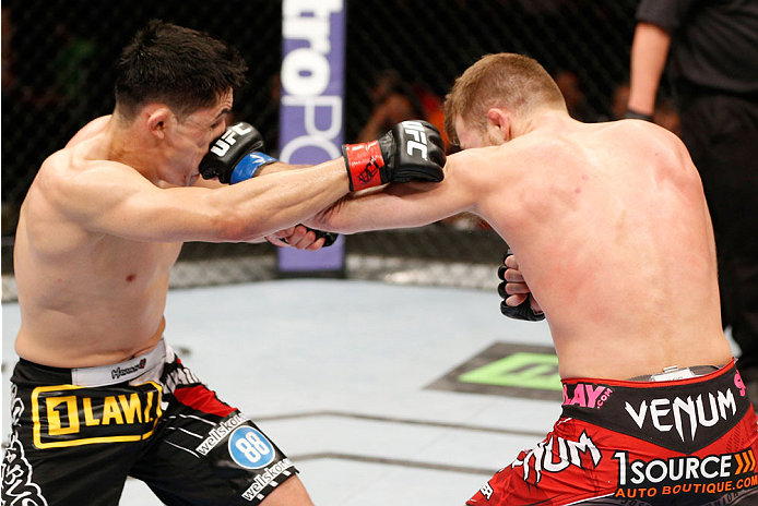 ALBUQUERQUE, NM - JUNE 07:  (R-L) Bryan Caraway punches Erik Perez in their bantamweight fight during the UFC Fight Night event at Tingley Coliseum on June 7, 2014 in Albuquerque, New Mexico.  (Photo by Josh Hedges/Zuffa LLC/Zuffa LLC via Getty Images)