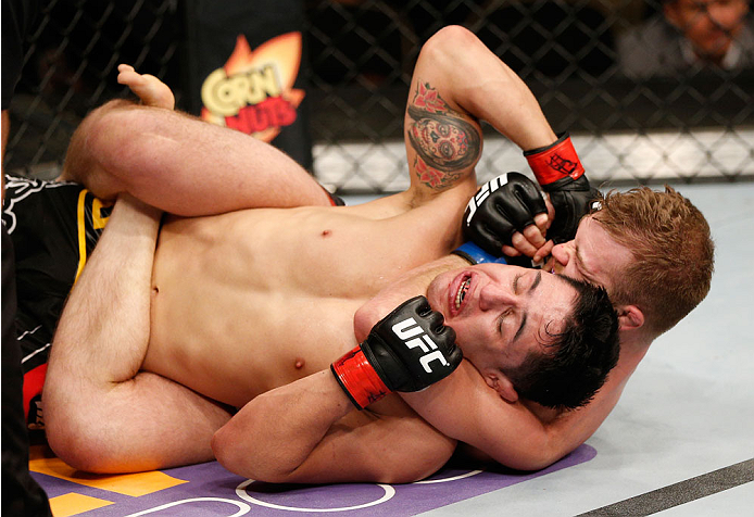 ALBUQUERQUE, NM - JUNE 07:  (R-L) Bryan Caraway secures a rear choke submission against Erik Perez in their bantamweight fight during the UFC Fight Night event at Tingley Coliseum on June 7, 2014 in Albuquerque, New Mexico.  (Photo by Josh Hedges/Zuffa LL