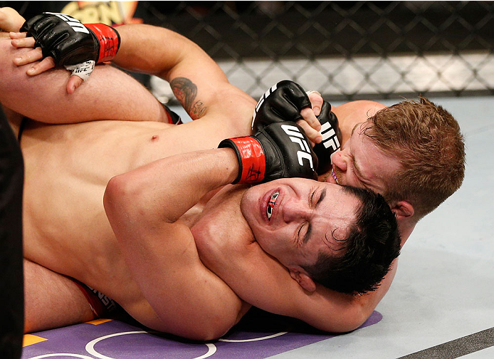 ALBUQUERQUE, NM - JUNE 07:  (R-L) Bryan Caraway secures a rear choke submission against Erik Perez in their bantamweight fight during the UFC Fight Night event at Tingley Coliseum on June 7, 2014 in Albuquerque, New Mexico.  (Photo by Josh Hedges/Zuffa LL