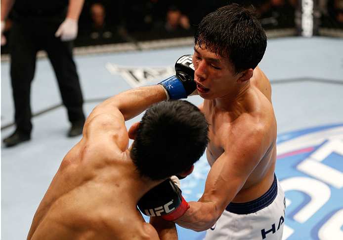 BRISBANE, AUSTRALIA - DECEMBER 07: (R-L) Takeya Mizugaki punches Nam Phan in their bantamweight fight during the UFC Fight Night event at the Brisbane Entertainment Centre on December 7, 2013 in Brisbane, Australia. (Photo by Josh Hedges/Zuffa LLC/Zuffa