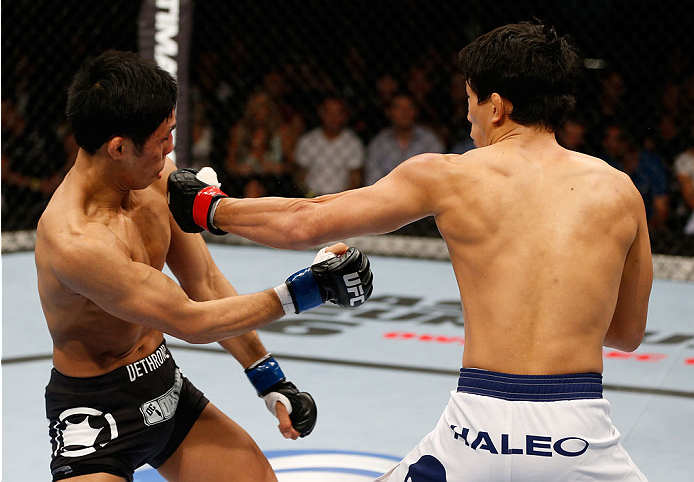 BRISBANE, AUSTRALIA - DECEMBER 07: (R-L) Takeya Mizugaki punches Nam Phan in their bantamweight fight during the UFC Fight Night event at the Brisbane Entertainment Centre on December 7, 2013 in Brisbane, Australia. (Photo by Josh Hedges/Zuffa LLC/Zuffa