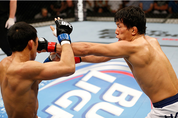 BRISBANE, AUSTRALIA - DECEMBER 07: (R-L) Takeya Mizugaki punches Nam Phan in their bantamweight fight during the UFC Fight Night event at the Brisbane Entertainment Centre on December 7, 2013 in Brisbane, Australia. (Photo by Josh Hedges/Zuffa LLC/Zuffa