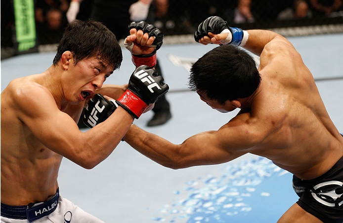 BRISBANE, AUSTRALIA - DECEMBER 07: (R-L) Nam Phan punches Takeya Mizugaki in their bantamweight fight during the UFC Fight Night event at the Brisbane Entertainment Centre on December 7, 2013 in Brisbane, Australia. (Photo by Josh Hedges/Zuffa LLC/Zuffa