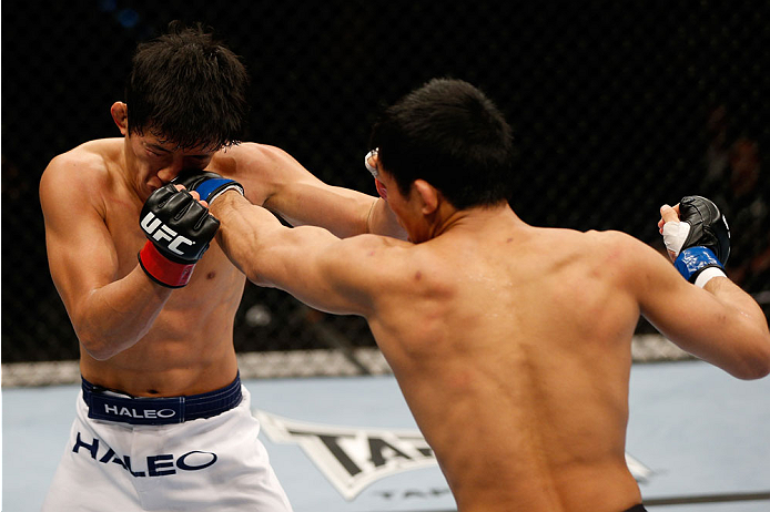 BRISBANE, AUSTRALIA - DECEMBER 07: (R-L) Nam Phan punches Takeya Mizugaki in their bantamweight fight during the UFC Fight Night event at the Brisbane Entertainment Centre on December 7, 2013 in Brisbane, Australia. (Photo by Josh Hedges/Zuffa LLC/Zuffa