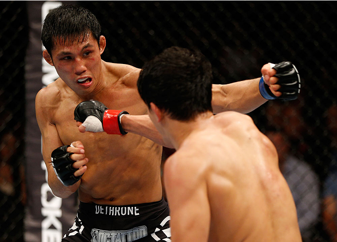BRISBANE, AUSTRALIA - DECEMBER 07: (L-R) Nam Phan and Takeya Mizugaki trade punches in their bantamweight fight during the UFC Fight Night event at the Brisbane Entertainment Centre on December 7, 2013 in Brisbane, Australia. (Photo by Josh Hedges/Zuffa