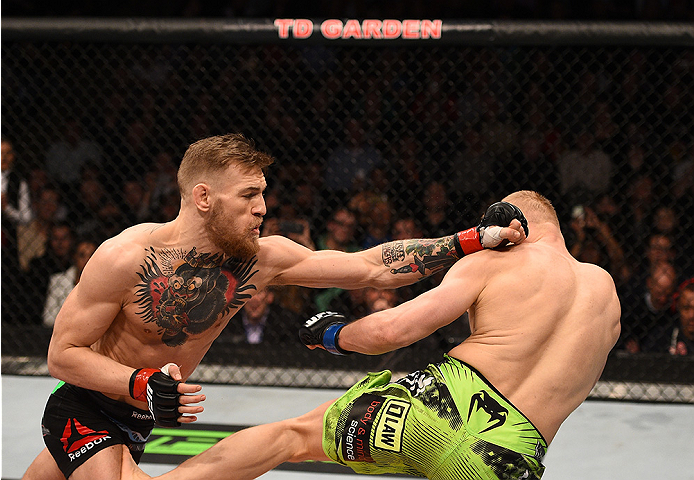 BOSTON, MA - JANUARY 18:  (L-R) Conor McGregor of Ireland punches Dennis Siver of Germany in their featherweight fight during the UFC Fight Night event at the TD Garden on January 18, 2015 in Boston, Massachusetts. (Photo by Jeff Bottari/Zuffa LLC/Zuffa L