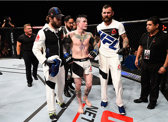 MONTERREY, MEXICO - NOVEMBER 21: Scott Jorgensen of the United States is helped out of the Octagon after suffering an injury against Alejandro Perez of Mexico in their bantamweight bout during the UFC Fight Night event at Arena Monterrey on November 21,