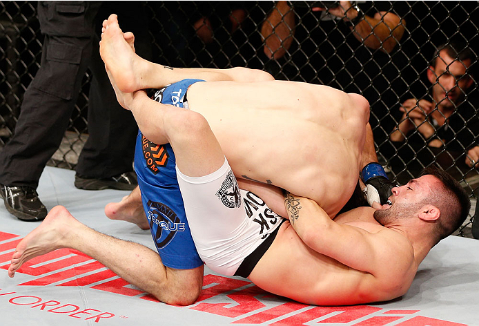 SAO PAULO, BRAZIL - MAY 31: (R-L) Pedro Munhoz attempts to secure a guillotine choke submission against Matt Hobar in their bantamweight fight during the UFC Fight Night event at the Ginasio do Ibirapuera on May 31, 2014 in Sao Paulo, Brazil. (Photo by Jo