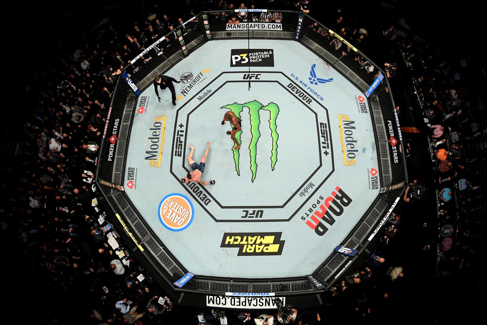 Kamaru Usman of Nigeria knocks down Colby Covington in their UFC welterweight championship bout during the UFC 245