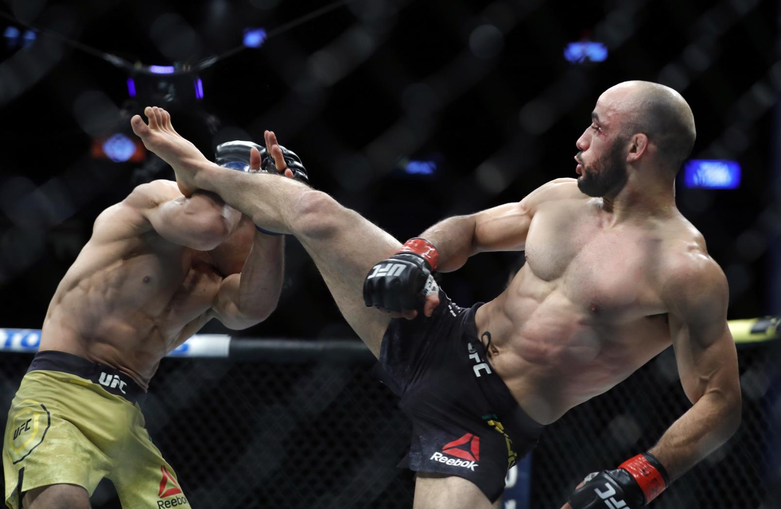 Jose Aldo (L) blocks a kick from Marlon Moraes in their bantamweight fight during UFC 245