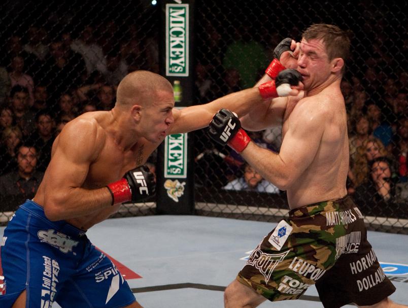 (L-R) Georges St-Pierre punches Matt Hughes at UFC 65 at the Arco Arena on November 18, 2006 in Sacramento, California. (Photo by Josh Hedges/Zuffa LLC)