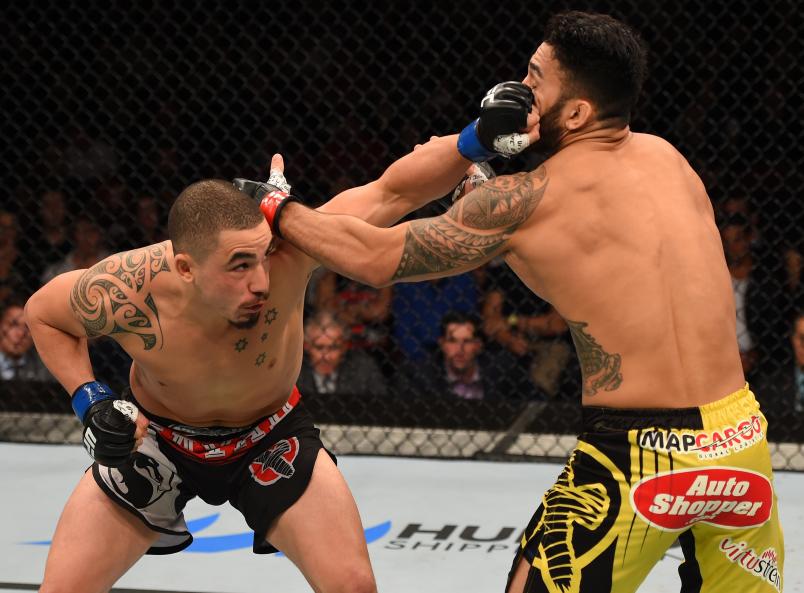 ADELAIDE, AUSTRALIA - MAY 10: (L-R) Robert Whittaker punches Brad Tavares in their middleweight bout during the UFC Fight Night event at the Adelaide Entertainment Centre on May 10, 2015 in Adelaide, Australia. (Photo by Josh Hedges/Zuffa LLC/Zuffa LLC via Getty Images)