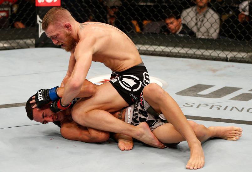 BOSTON, MA - AUGUST 17: (R-L) Conor McGregor punches Max Holloway in their UFC featherweight bout at TD Garden on August 17, 2013 in Boston, Massachusetts. (Photo by Josh Hedges/Zuffa LLC/Zuffa LLC via Getty Images)