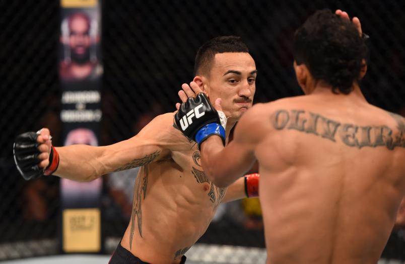 Max Holloway of the United States punches Charles Oliveira of Brazil in their featherweight bout during the UFC event at the SaskTel Centre on August 23, 2015 in Saskatoon, Saskatchewan, Canada. (Photo by Jeff Bottari/Zuffa LLC/Zuffa LLC)