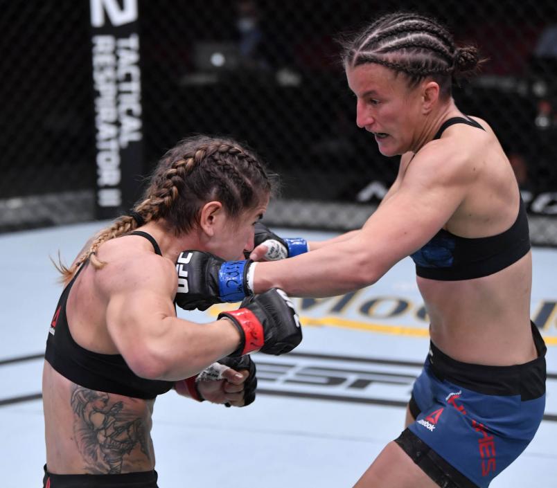 Sam Hughes punches Tecia Torres in their women's strawweight bout during the UFC 256 event at UFC APEX on December 12, 2020 in Las Vegas, Nevada. (Photo by Jeff Bottari/Zuffa LLC)