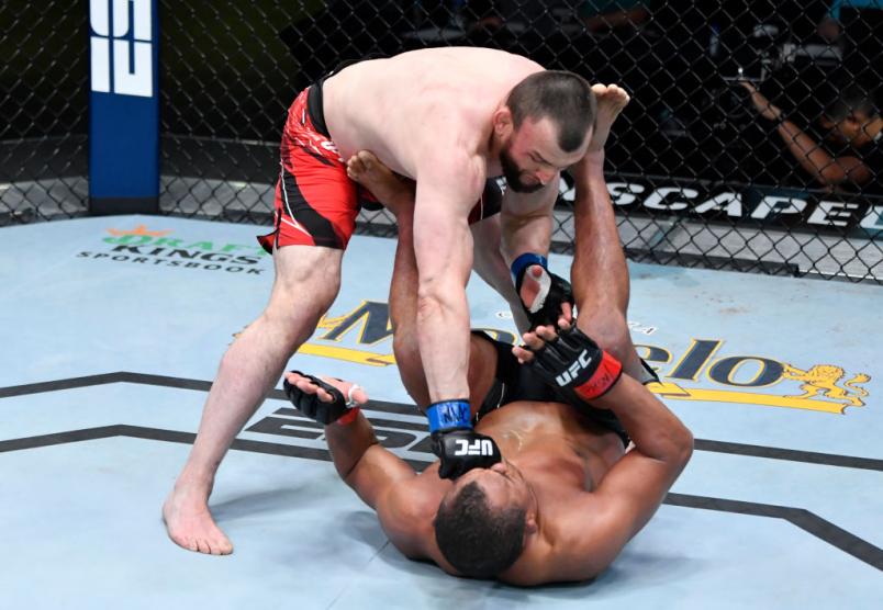 Muslim Salikhov, em pé, aplica soco em Francisco Massaranduba, de costas no chão, no UFC Vegas 28