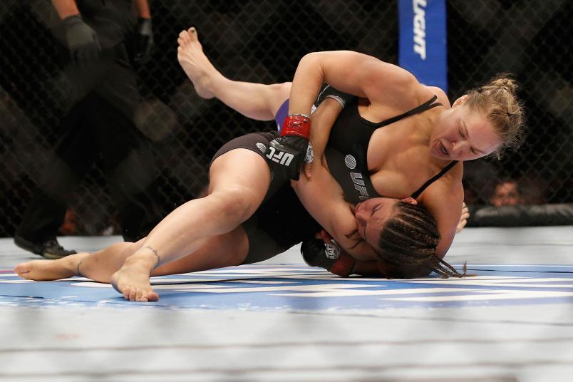 Ronda Rousey (top) punches Alexis Davis while controlling her body in their UFC women's bantamweight championship fight at UFC 175 inside the Mandalay Bay Events Center on July 5, 2014 in Las Vegas, Nevada. (Photo by Josh Hedges/Zuffa LLC)