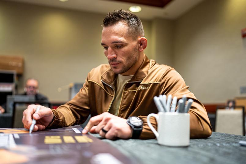 Michael Chandler autographs the official UFC 268 poster in UFC 268 (Photo by Nolan Walker/Zuffa LLC)