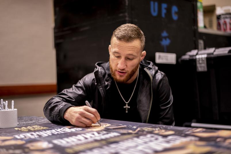 Justin Gaethje signs the UFC 268 official event poster (Photo by Braydon Jackson/Zuffa LLC)
