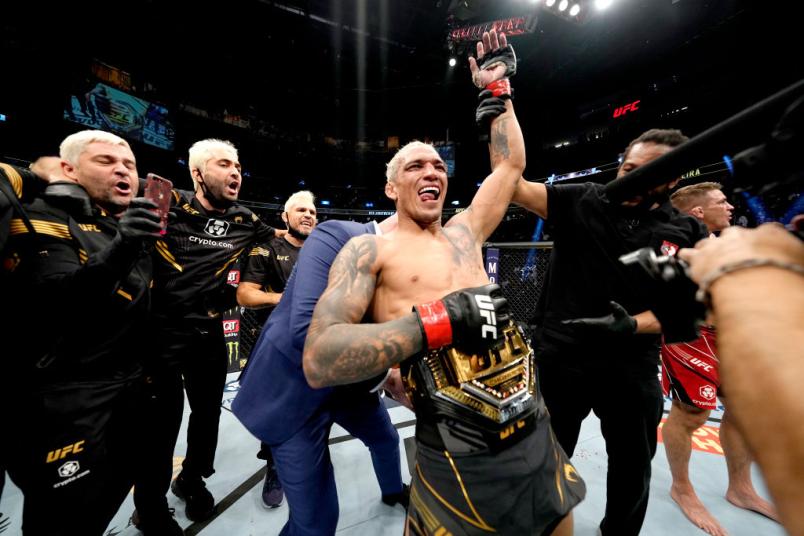 Charles Oliveira tem o braço erguido e recebe o cinturão após vencer Dustin Poirier no UFC 269