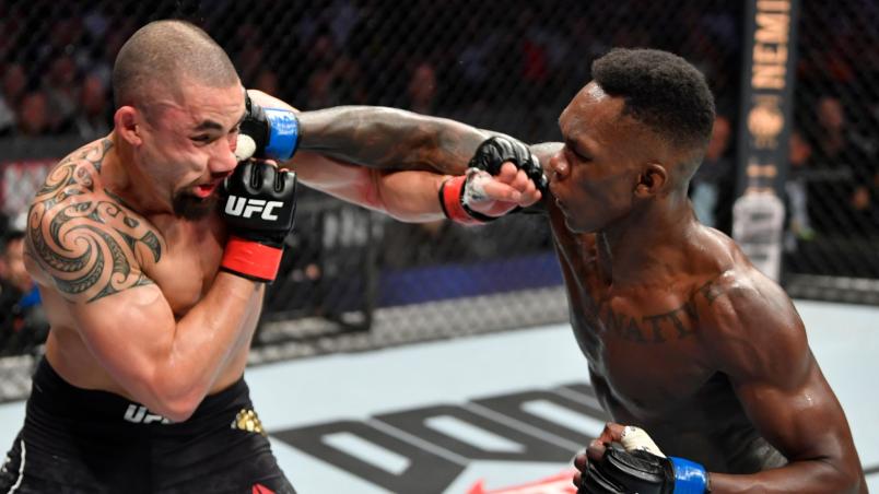 Israel Adesanya conecta cruzado de direita em Robert Whittaker.