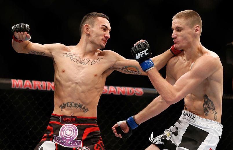 Max Holloway punches Will Chope in their featherweight bout during the UFC Fight Night event at the Marina Bay Sands Resort on January 4, 2014 in Singapore. (Photo by Josh Hedges/Zuffa LLC/Zuffa LLC via Getty Images)
