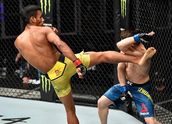 Raulian Paiva chuta Zhalgas Zhumagulov no UFC 251. (Foto por Jeff Bottari/Zuffa LLC)