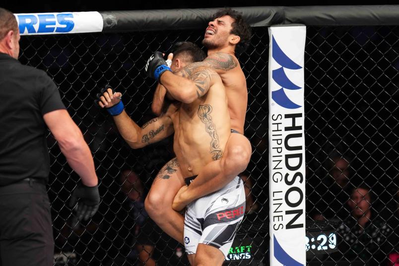 Alexandre Pantoja of Brazil attempts to submit Alex Perez in a flyweight fight during the UFC 277 event