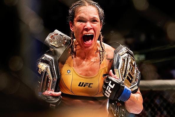 Amanda Nunes comemora a vitória no UFC 277 com seus dois cinturões. (Foto por Carmen Mandato/Getty Images)