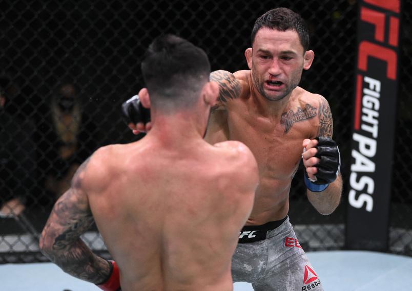 Frankie Edgar punches Pedro Munhoz of Brazil in their bantamweight fight during the UFC Fight Night event at UFC APEX