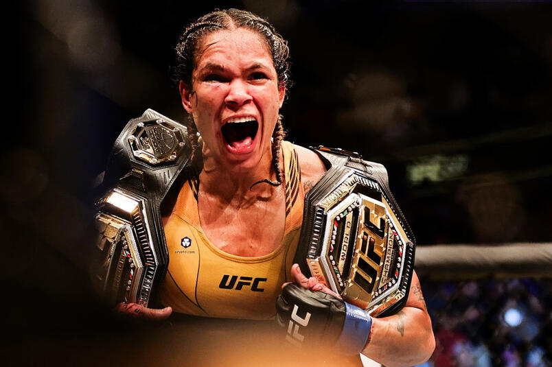 Amanda Nunes comemora a vitória no UFC 277 com seus dois cinturões. (Foto por Carmen Mandato/Getty Images)