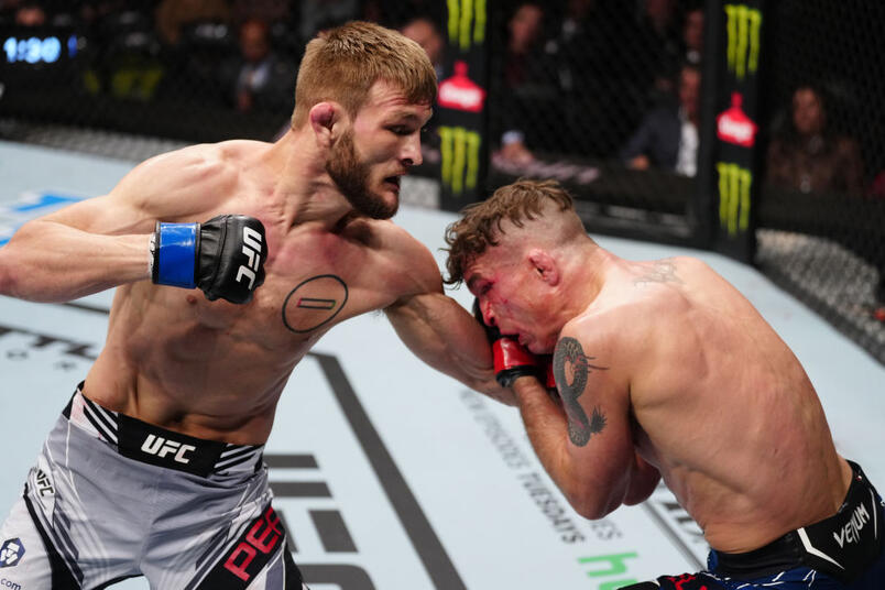 Jonathan Pearce punches Darren Elkins in a featherweight fight during the UFC Fight Night event at Amway Center on December 03, 2022 in Orlando, Florida. (Photo by Jeff Bottari/Zuffa LLC)