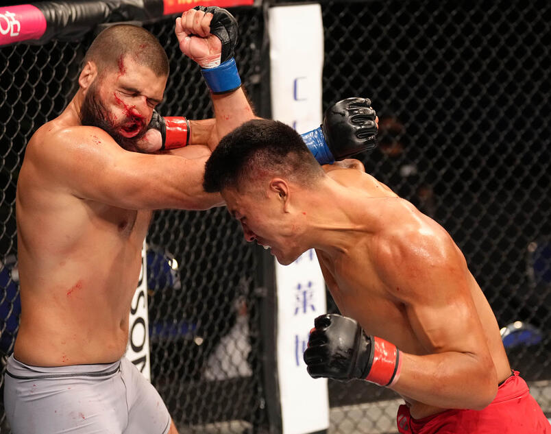 Zhang Mingyang of China punches Tuco Tokkos of England during the Road to UFC event at Singapore Indoor Stadium on June 09, 2022 in Singapore. (Photo by Jeff Bottari/Zuffa LLC)
