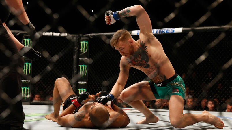 LAS VEGAS, NV - DECEMBER 12: Conor McGregor of Ireland (top) punches Jose Aldo of Brazil in their UFC featherweight championship bout during the UFC 194 event inside MGM Grand Garden Arena on December 12, 2015 in Las Vegas, Nevada. (Photo by Christian P