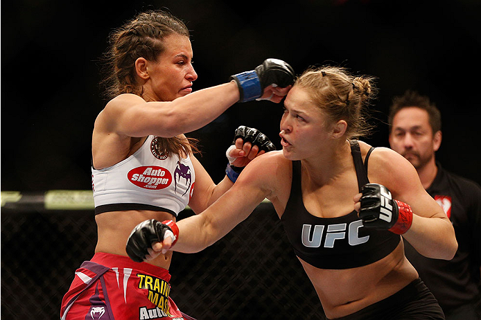 LAS VEGAS, NV - DECEMBER 28:  (L-R) Miesha Tate and Ronda Rousey exchange punches in their UFC women's bantamweight championship bout during the UFC 168 event at the MGM Grand Garden Arena on December 28, 2013 in Las Vegas, Nevada. (Photo by Josh Hedges/Z