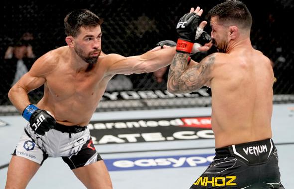 Dominick Cruz punches Pedro Munhoz of Brazil in their bantamweight bout during the UFC 269 on December 11, 2021 in Las Vegas, Nevada. (Photo by Jeff Bottari/Zuffa LLC)