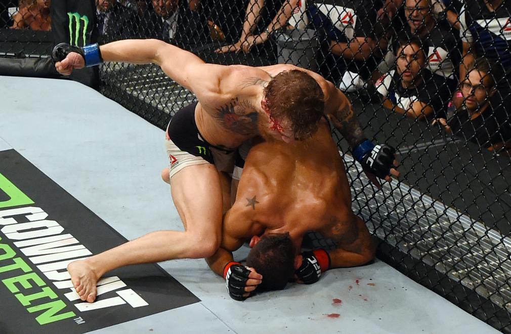 LAS VEGAS, NV - JULY 11: Conor McGregor (top) punches Chad Mendes in their UFC interim featherweight title fight during the UFC 189 event inside MGM Grand Garden Arena on July 11, 2015 in Las Vegas, Nevada. (Photo by Josh Hedges/Zuffa LLC/Zuffa LLC via Getty Images)